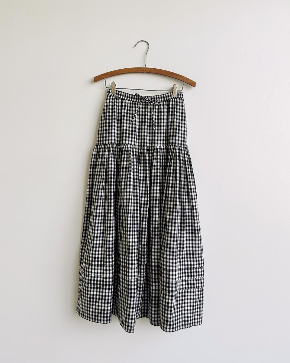 Gardenne Skirt in Prairie Noir — vintage-inspired cotton gingham midi skirt with drawstring waist and pleated hem.