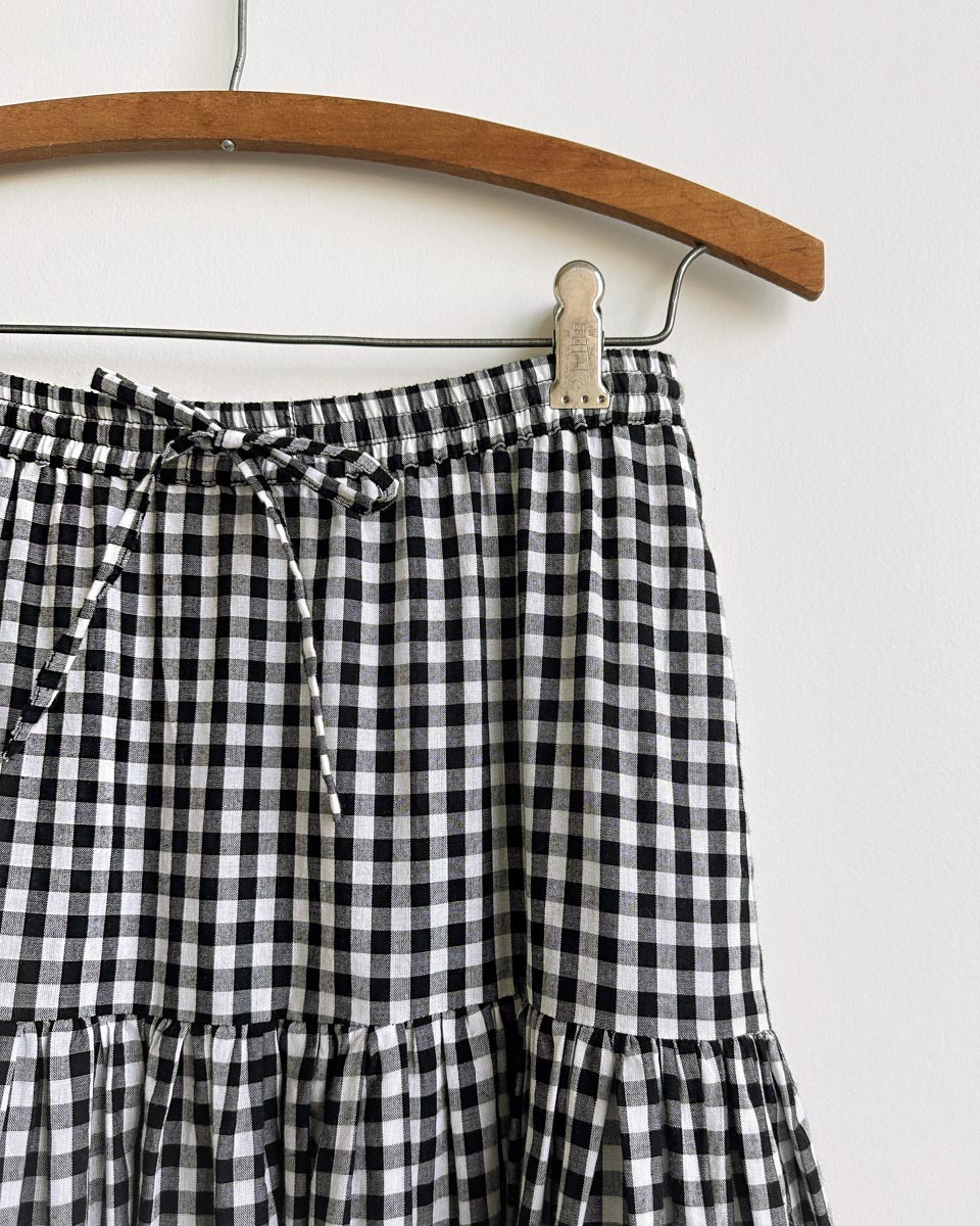 Gardenne Skirt in Prairie Noir — vintage-inspired cotton gingham midi skirt with drawstring waist and pleated hem.
