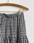 Gardenne Skirt in Prairie Noir — vintage-inspired cotton gingham midi skirt with drawstring waist and pleated hem.