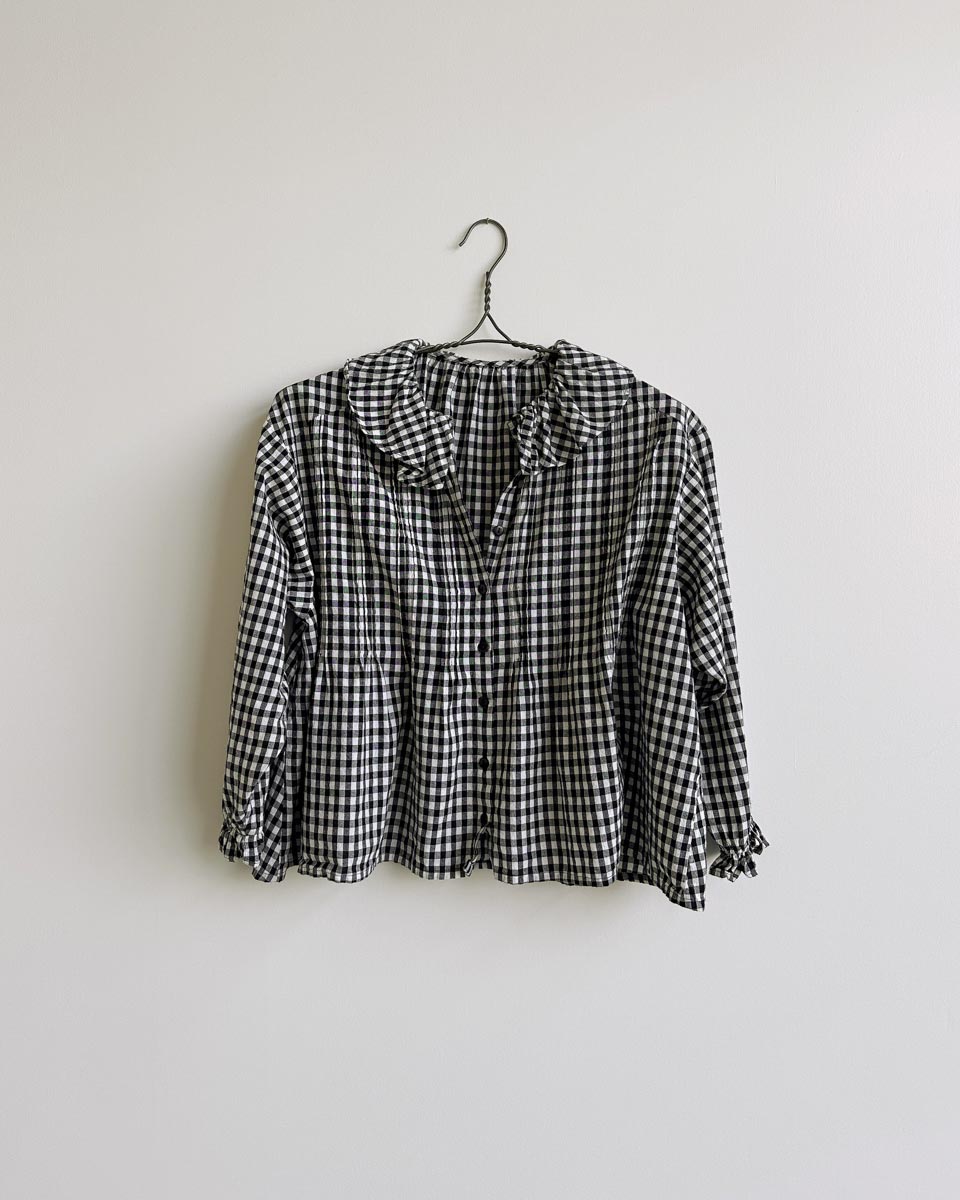 Nesaea Top in Prairie Noir — vintage-inspired black and white gingham blouse with ruffles and puff sleeves.
