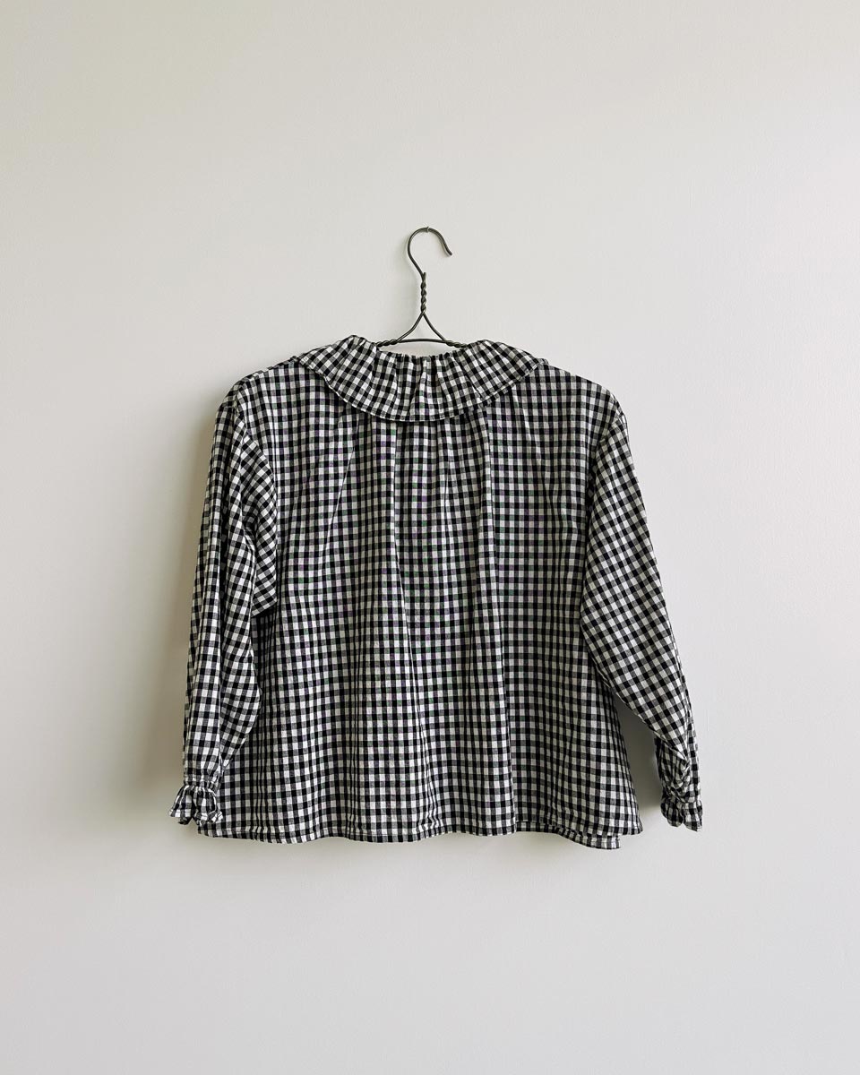 Nesaea Top in Prairie Noir — vintage-inspired black and white gingham blouse with ruffles and puff sleeves.