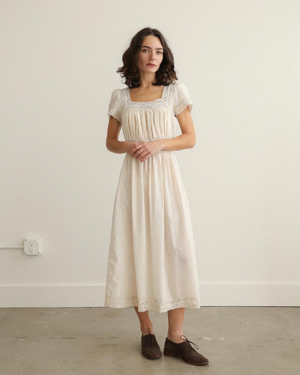 Theodosia Dress — romantic cream cotton gauze midi with lace trim, puff sleeves, and tie-back sash, ethically made in India.