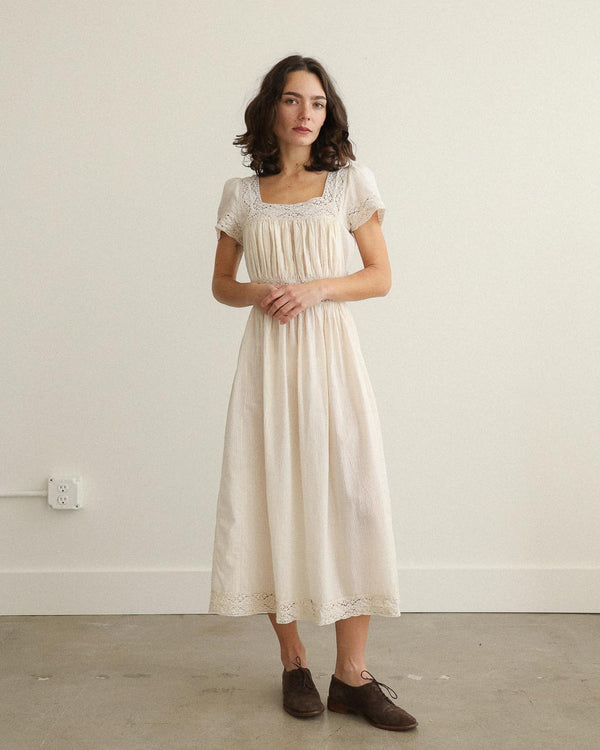 Theodosia Dress — romantic cream cotton gauze midi with lace trim, puff sleeves, and tie-back sash, ethically made in India.